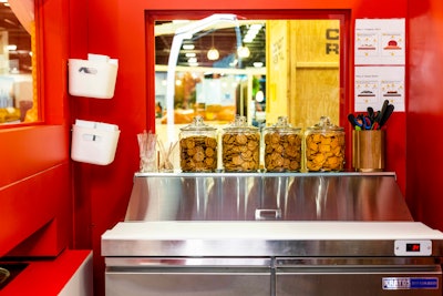 The booth included a fully functional kitchen with a fridge, a sink, storage, and access to the conveyor belt.
